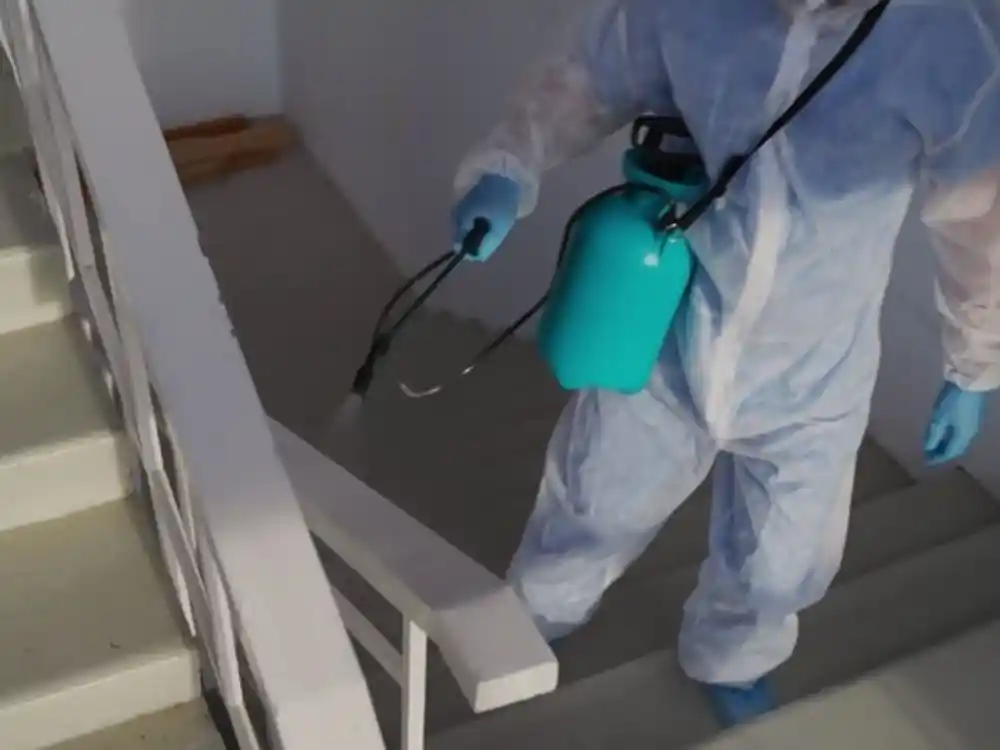 Technician in a crawlspace applying antimicrobial treatment to joists with a sprayer — Crawlspace Mold Remediation in Fairfax, VA