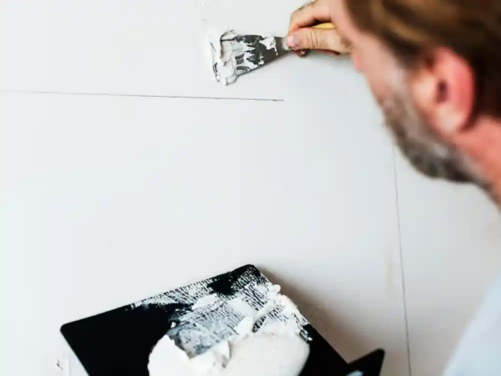Technician installing or taping a fresh drywall patch section mid-repair — Drywall Water Damage Repair in Fairfax, VA