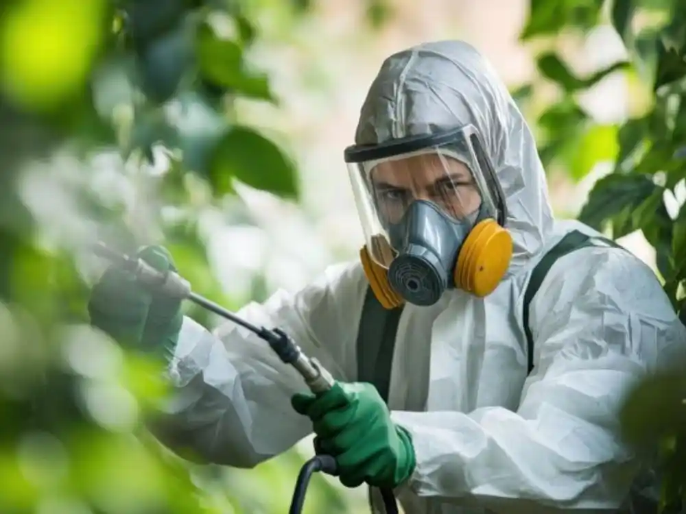 Technician in full biohazard PPE with a marked equipment case, arriving at a job site — Unattended Death Cleanup in Fairfax, VA